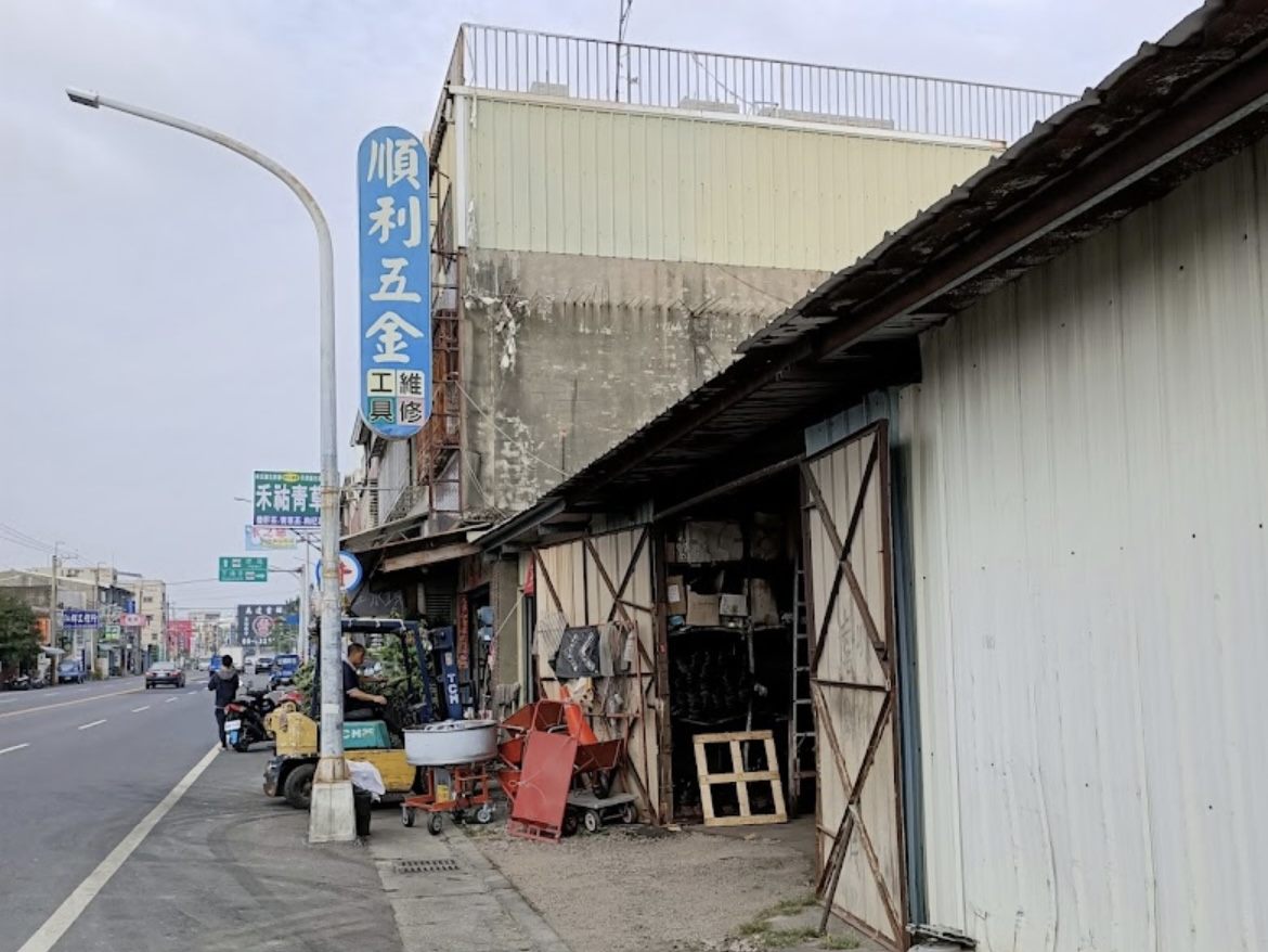 順利五金行の道路脇に立つ青い縦型看板と店舗の外観