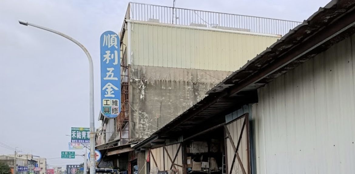 The blue roadside vertical sign for Shun Li Hardware